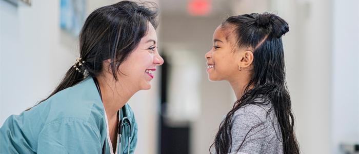 A nurse talks with a young girl. 