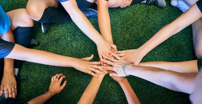 group of people putting their hands in a circle